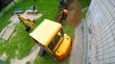 Excavator and road workers digging a trench for laying cables Stock Footage 63777568