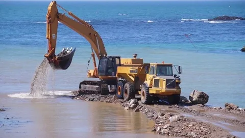 Excavator and truck moving sand working on beach slow motion 4k Stock Footage