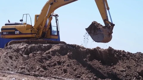 Excavator and truck moving sand working on beach slow motion Stock Footage