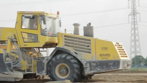 Excavator and trucks driving, digging and loading dirt on a construction yard Stock Footage 136567486