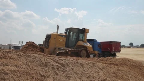 Excavator and trucks driving, digging and loading dirt on a construction yard Stock Footage 136569151