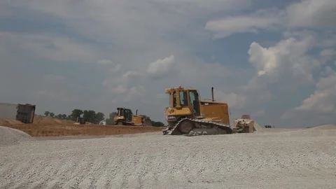 Excavator and trucks driving, digging and loading dirt on a construction yard Stock Footage 136569445