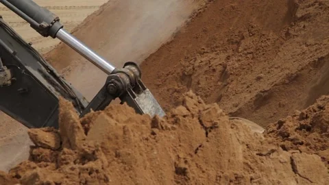 Excavator and trucks driving, digging and loading dirt on a construction yard Stock Footage 136572359