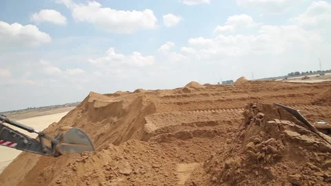 Excavator and trucks driving, digging and loading dirt on a construction yard Stock Footage 136572409