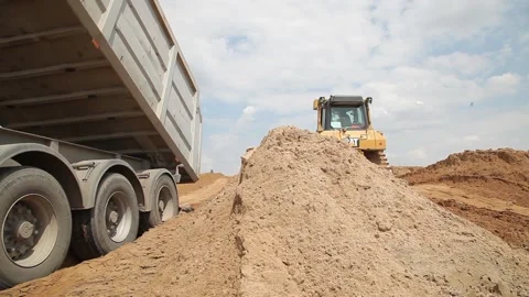 Excavator and trucks driving, digging and loading dirt on a construction yard Stock Footage 136578047