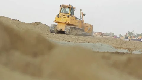 Excavator and trucks driving, digging and loading dirt on a construction yard Stock Footage 136826344