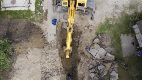 Excavator and workers digging a pipe hole Stock Photos