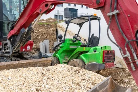 Excavator arm and compact loader working on construction site Fotos Stock