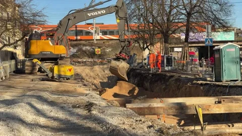 Excavator backfilling trench after underground utility repair at urban construct Stock Footage 331593069