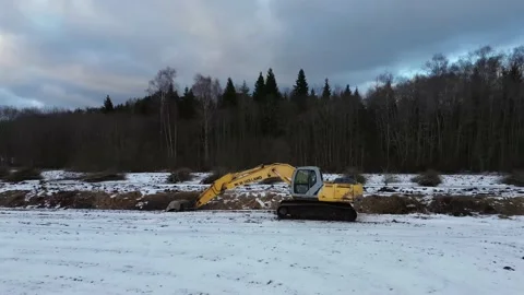 Excavator besides river in the winter time in 4K Stock Footage 234919414