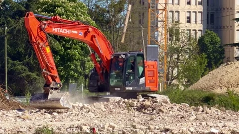 Excavator breaking up concrete and rocks on construction site Stock Footage 335966463