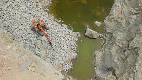 Excavator Breaking Stone in Deep Quarry From Above Video stock 341634923