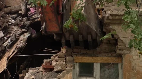 Excavator bucket destroys an old house close-up Stock Footage