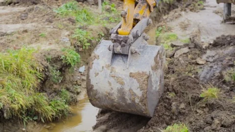 Excavator bucket digging a drainage ditch on a construction site. Video stock 73042465