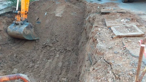 Excavator bucket digging a hole at construction site Stock Footage 97762145
