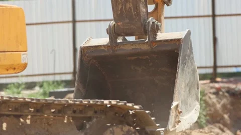 Excavator bucket digging sand at construction site Stock Footage 347834320
