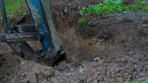 Excavator bucket digging soil at construction site Stock Footage 315941775