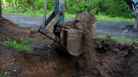 Excavator bucket digging soil at construction site Stock Footage 315941809