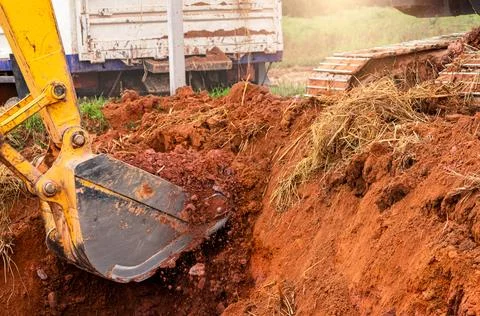 Excavator bucket digging soil for loading to truck. Earthwork. Dirt metal b.. 스톡 사진