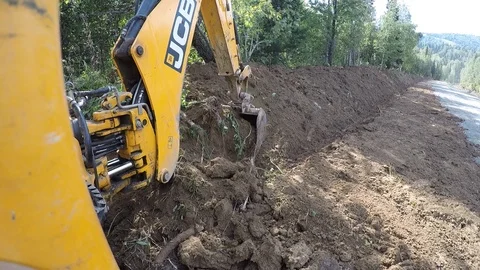 Excavator with bucket digging a trench Stock Footage 96580158