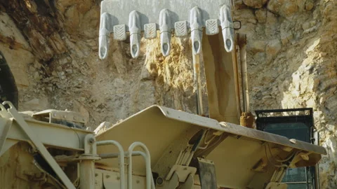 Excavator bucket loading stone pieces in crushing machine in quarry,rocks mining Video stock 293962895