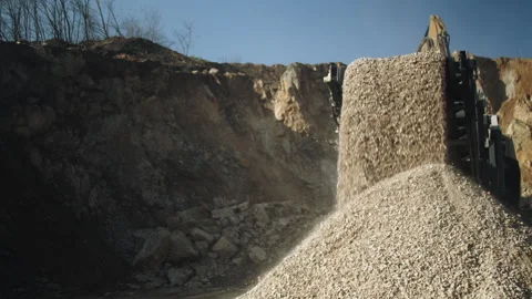 Excavator bucket loading stone pieces in crushing machine, quarry work process Video stock 294062437