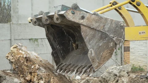 Excavator bucket, rocks, demolition machine pushes construction debris Stock Footage 313120892