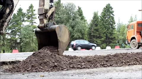 Excavator bucket, which leveled the ground in preparation for road asphalting Stock Footage 66685546
