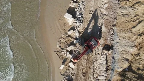 Excavator build a wall  from boulder on the beach Video stock 144554711