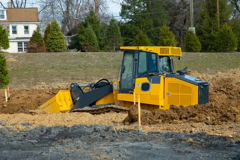 Excavator at building under construction backhoe digs the ground for the foun Stock Photos