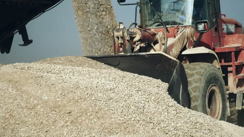 Excavator bulldozer operator loading gravel, crushing machine conveyor belt Video stock 294090040