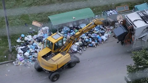 Excavator cleans up huge garbage heap on street. Stock Footage 78053484