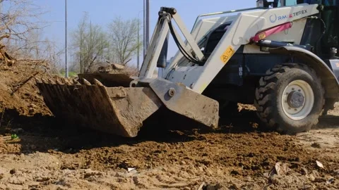 Excavator clears dump of garbage, dead trees. Mechanized cleaning of territory Video stock 323432409
