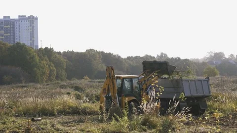 An excavator clears a field for the development of the district Stock Footage 140683558