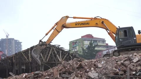 The excavator clears the rubble of the house Stock Footage 217729591