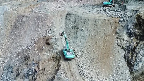Excavator climbing a rocky mountain in a mining area Stock Footage 312274375
