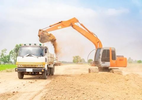Excavator construction machine loading soil into dump Truck . Stock Photos