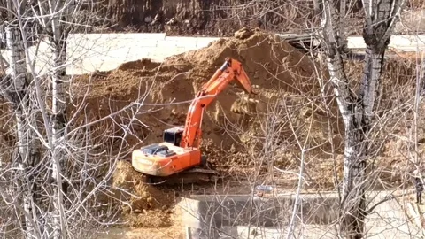 An excavator at a construction site digs a hole. Stock Footage 104407973