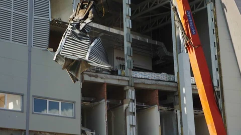 Excavator with cutter disassembles debris at demolition site Stock Footage 127741615