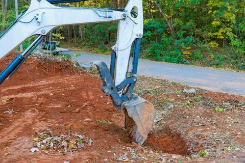 Excavator dig trenches to lay pipe through which rainwater will flow to a Stock Photos