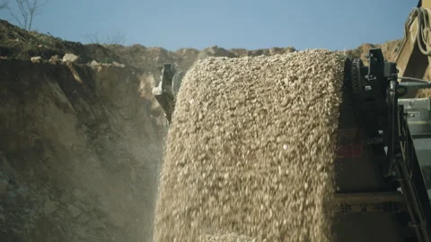 Excavator digging and loading stone pieces in rock crushing machine, open pit Video stock 294072233