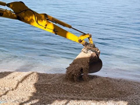 Excavator digging on beach Фото