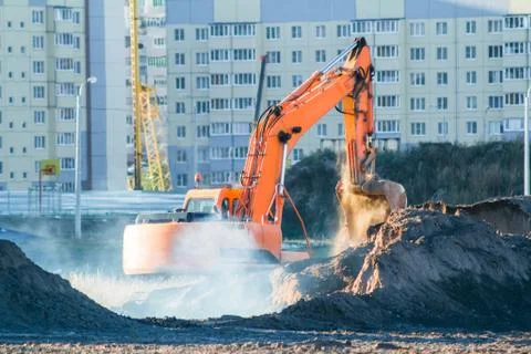 Excavator digging the ground at the construction site. Stock Photos