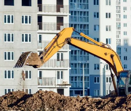 Excavator digging the ground at the construction site. Stock Photos