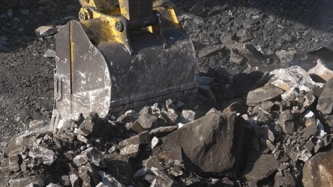 Excavator digging ore close-up. Bucket excavator rakes rock. Open pit mining. 库存影片 94601031