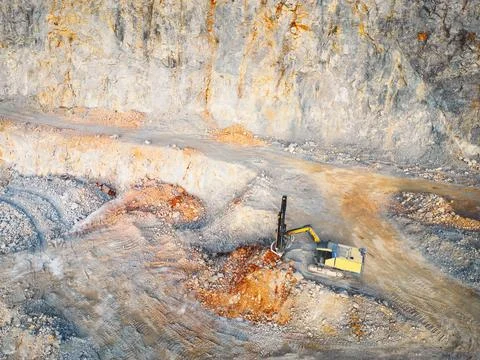Excavator digging a pit in the quarry - Small open pit quarry Stock Photos