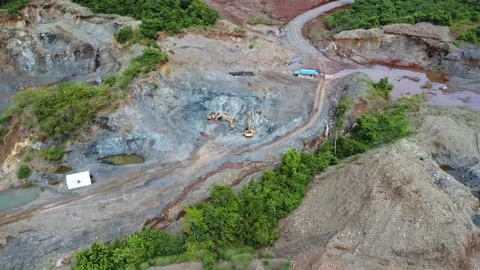Excavator digging rocks to be loaded onto a truck in a stone mining area, b.. Stock Footage 312298017