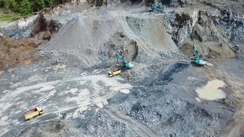 Excavator digging rocks to be loaded onto a truck in a stone mining area, b.. Stock Footage 312298180