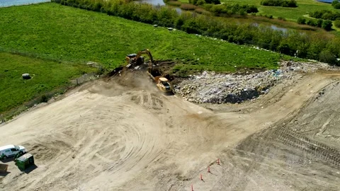 Excavator digging up soil and load on truck, drone stock footage Stock Footage 140048636