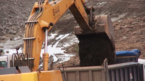 Excavator digs the ground on the construction site and pours it into the truck  Stock Footage 92200147